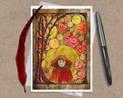Greeting card with autumn-themed design featuring a person in a red hood and colorful leaves on a brown background.