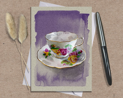 Greeting card with a teacup design on a textured surface with a pen and dried plants.