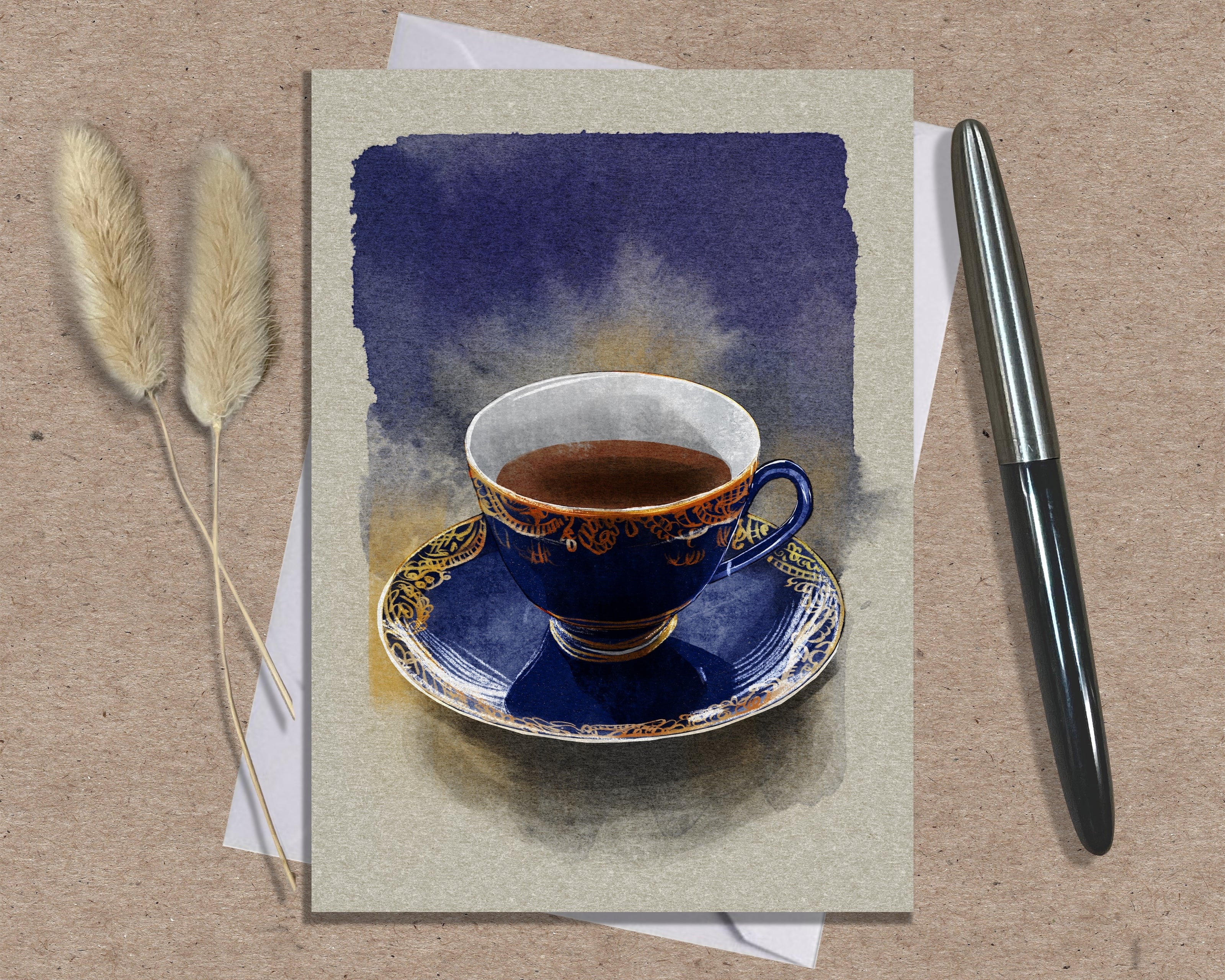 Card with a painting of a blue teacup and saucer on a textured surface with a pen and dried plants.