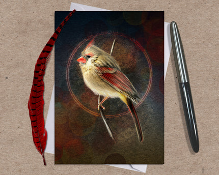 Card with a bird illustration on a textured surface with a pen and feather.