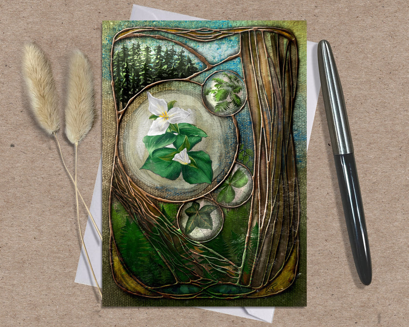 Decorative card with floral design on a textured surface with a pen and dried plants.