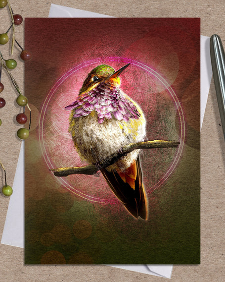 Greeting card with a hummingbird design on a textured surface with a pen and decorative elements.