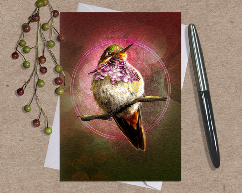 Greeting card with a hummingbird design on a textured surface with a pen and decorative elements.