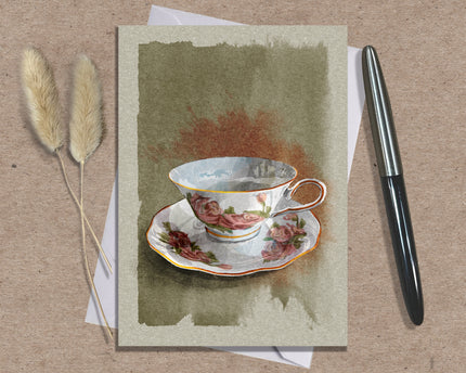 Greeting card with a teacup design on a textured surface with a pen and dried plants.
