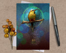 Greeting card with a colorful bird illustration on a textured surface with a pen and decorative elements.