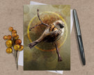 Greeting card with a bird illustration on a textured surface with a pen and decorative branch.