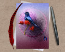 Greeting card with a blue bird and red flowers on a purple background, accompanied by a pen and feather.