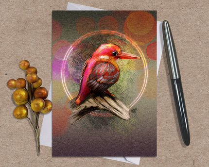 Card with a colorful bird illustration on a textured surface with a pen and decorative branch.