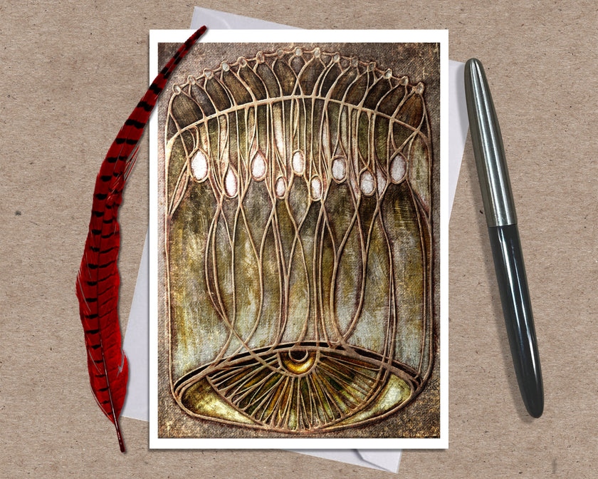Greeting card with intricate design on a brown background with a pen and feather.