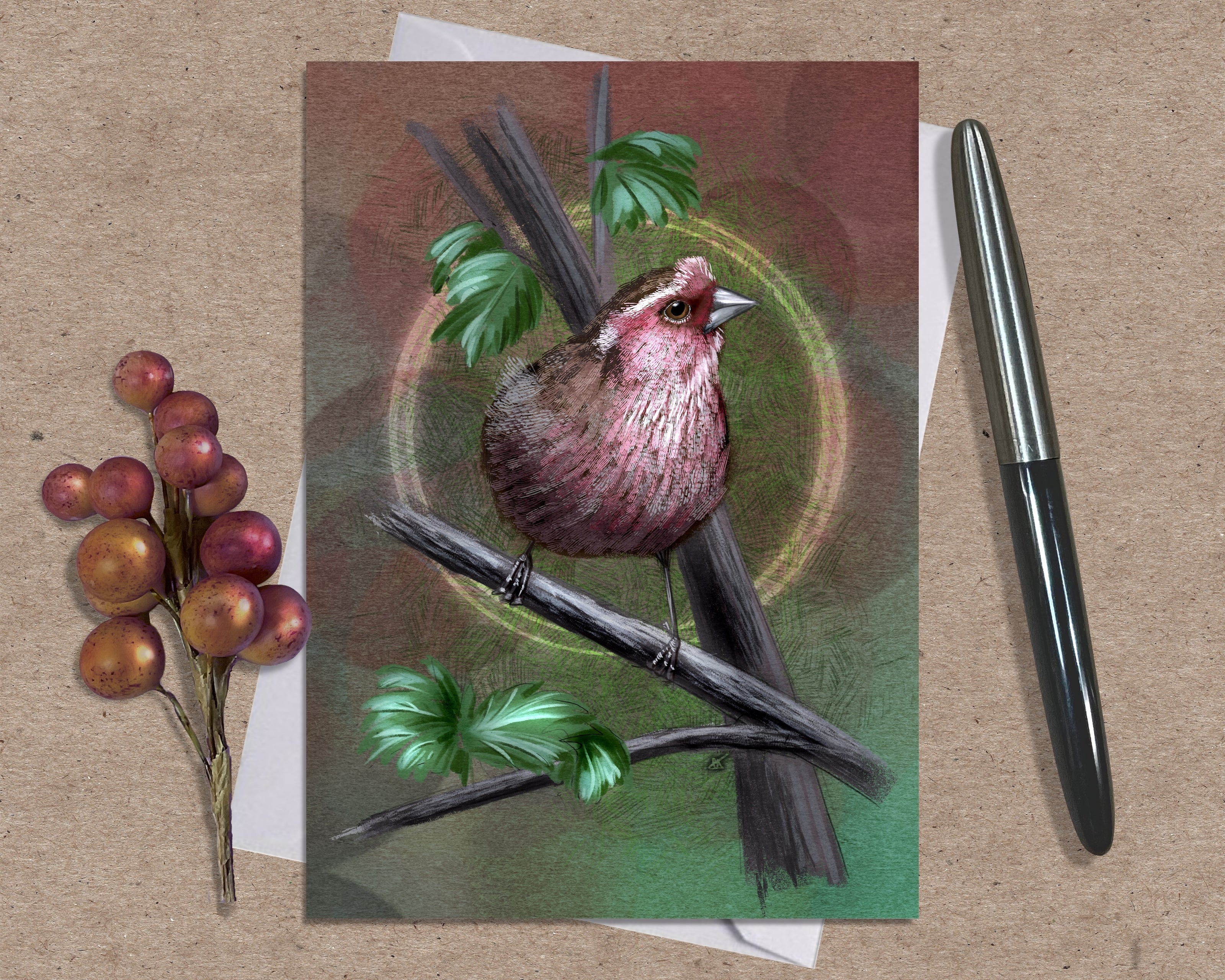 Card with a bird illustration on a branch with leaves and berries, placed on a textured surface with a pen and small plant.
