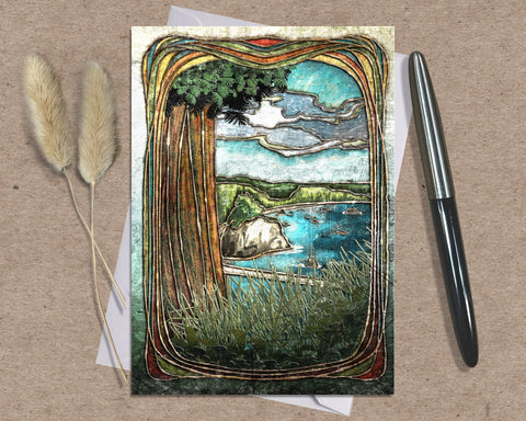 Greeting card with nature-themed design on a textured surface with a pen and dried plants.