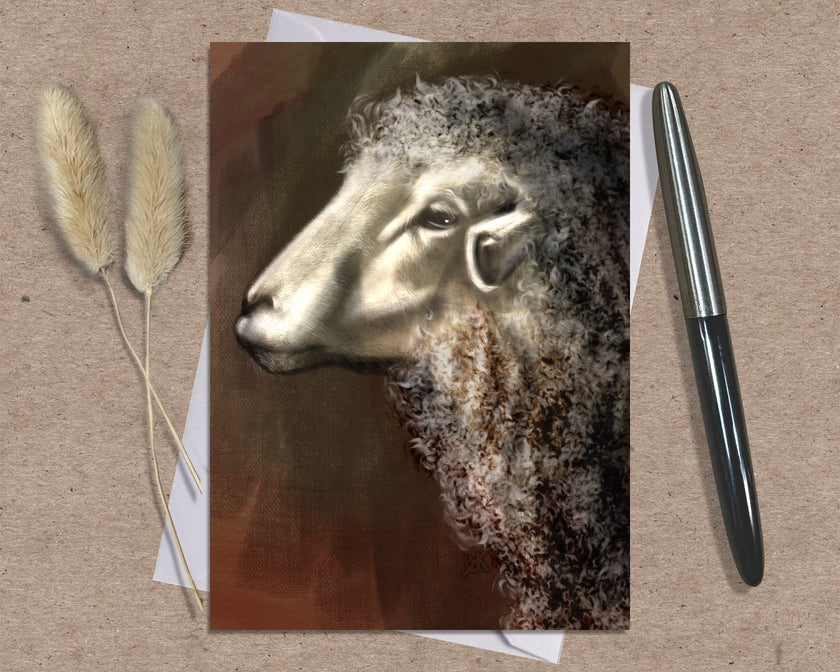 Greeting card with a sheep illustration on a textured surface with a pen and dried plants.