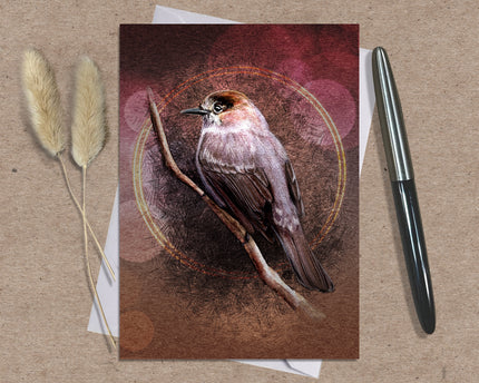 Card with a bird illustration on a brown background with a pen and dried plants.