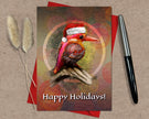 Greeting card with a bird wearing a Santa hat and 'Happy Holidays!' text, on a textured surface with a pen and dried plants.