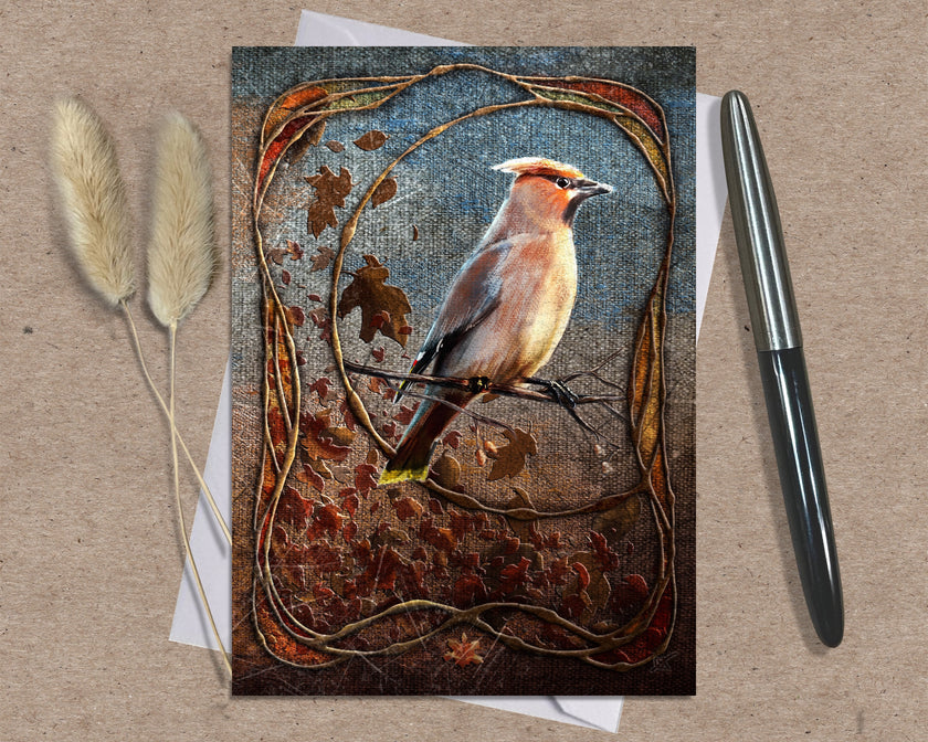 Greeting card with a bird design on a textured surface with a pen and dried plants.