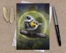 Card with a bird illustration on a textured surface with a pen and dried plants.