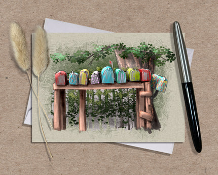 Greeting card with colorful mailbox design on a wooden bench, pen, and dried plants on a brown background